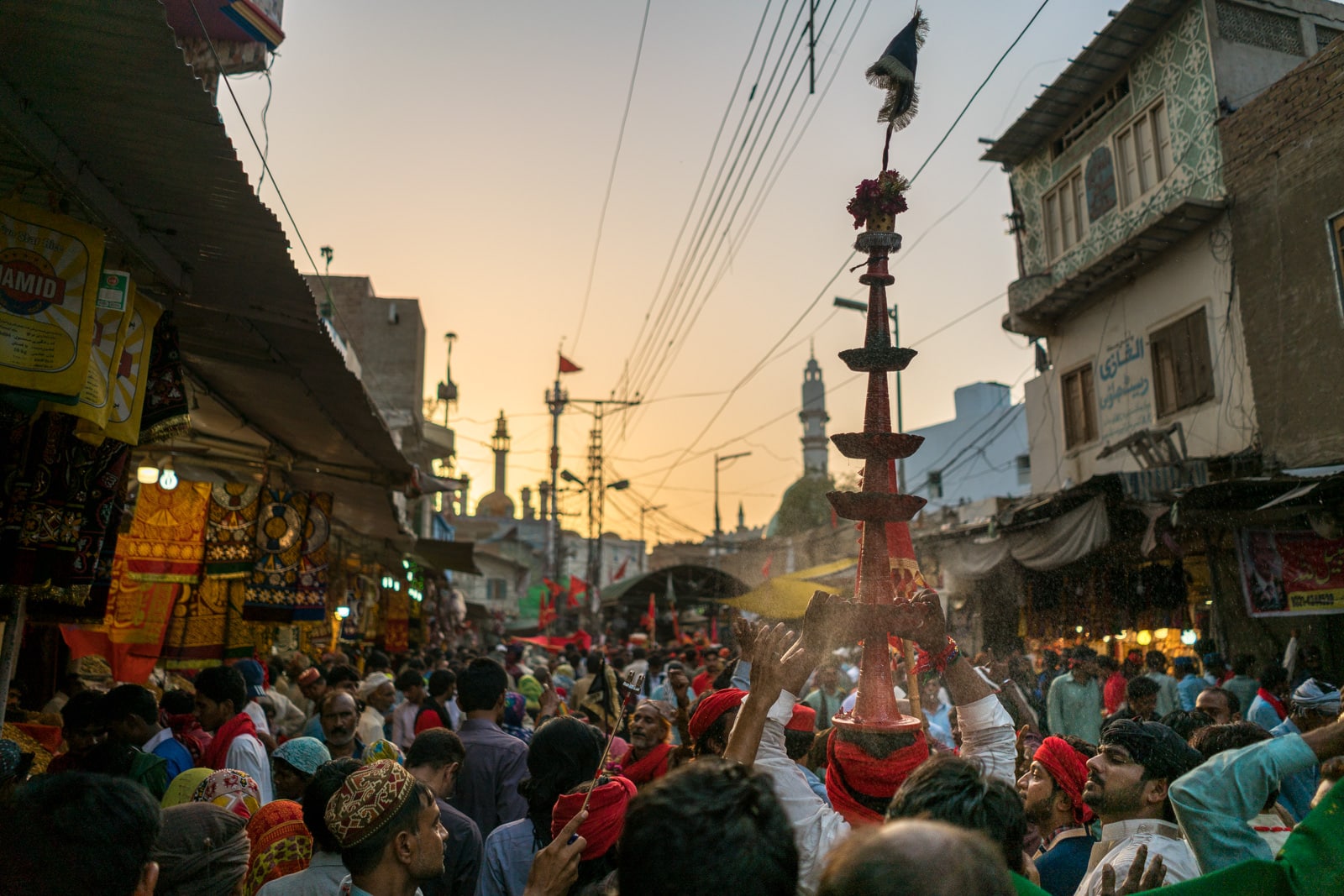 The Urs of Lal Shahbaz Qalandar in Sehwan, Pakistan - Busy streets and man carrying tower - Lost With Purpose travel blog